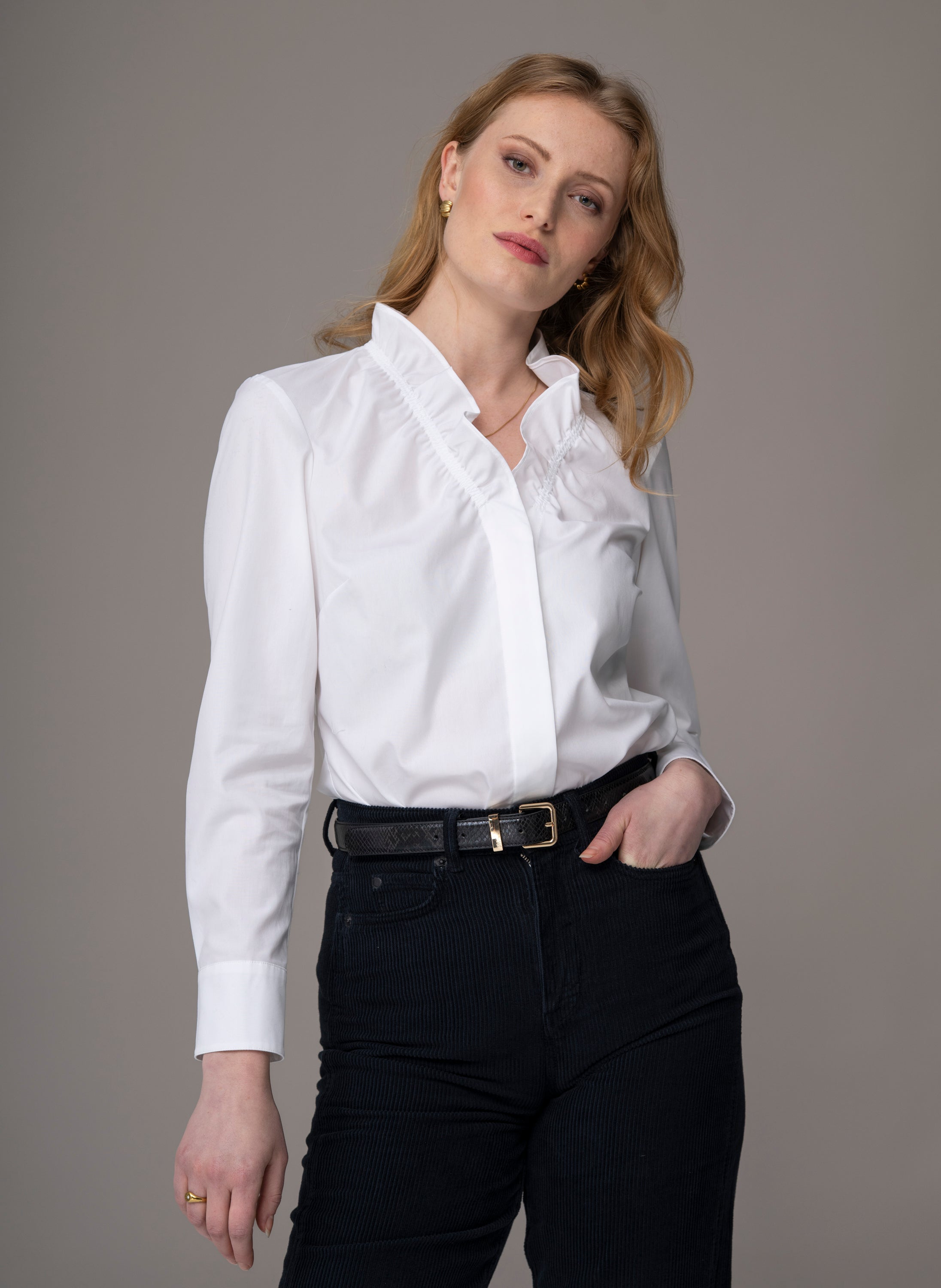 Woman wearing a white blouse with ruffled details 