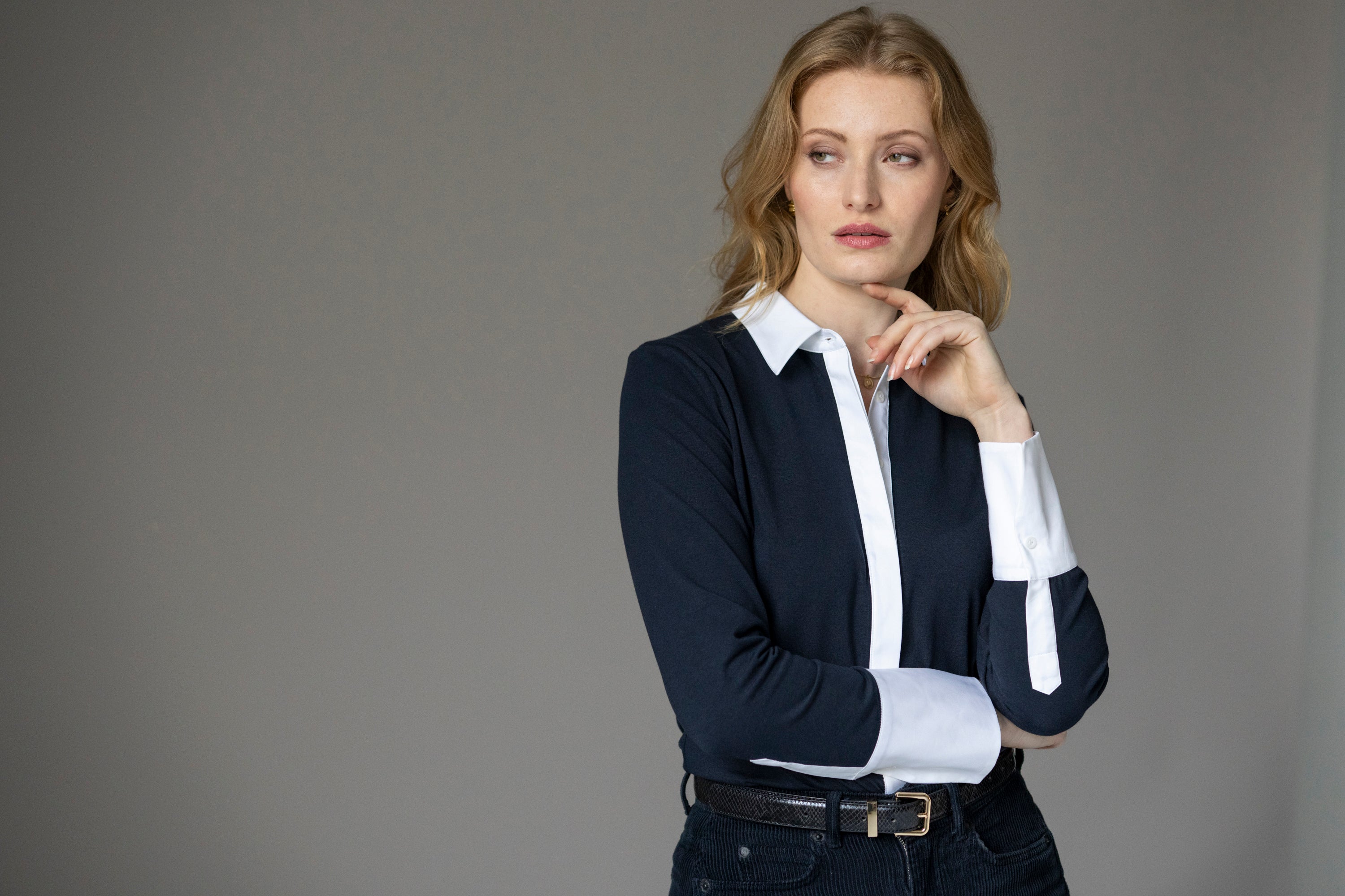 Woman wearing a navy jersey shirt with white cuffs and white collar