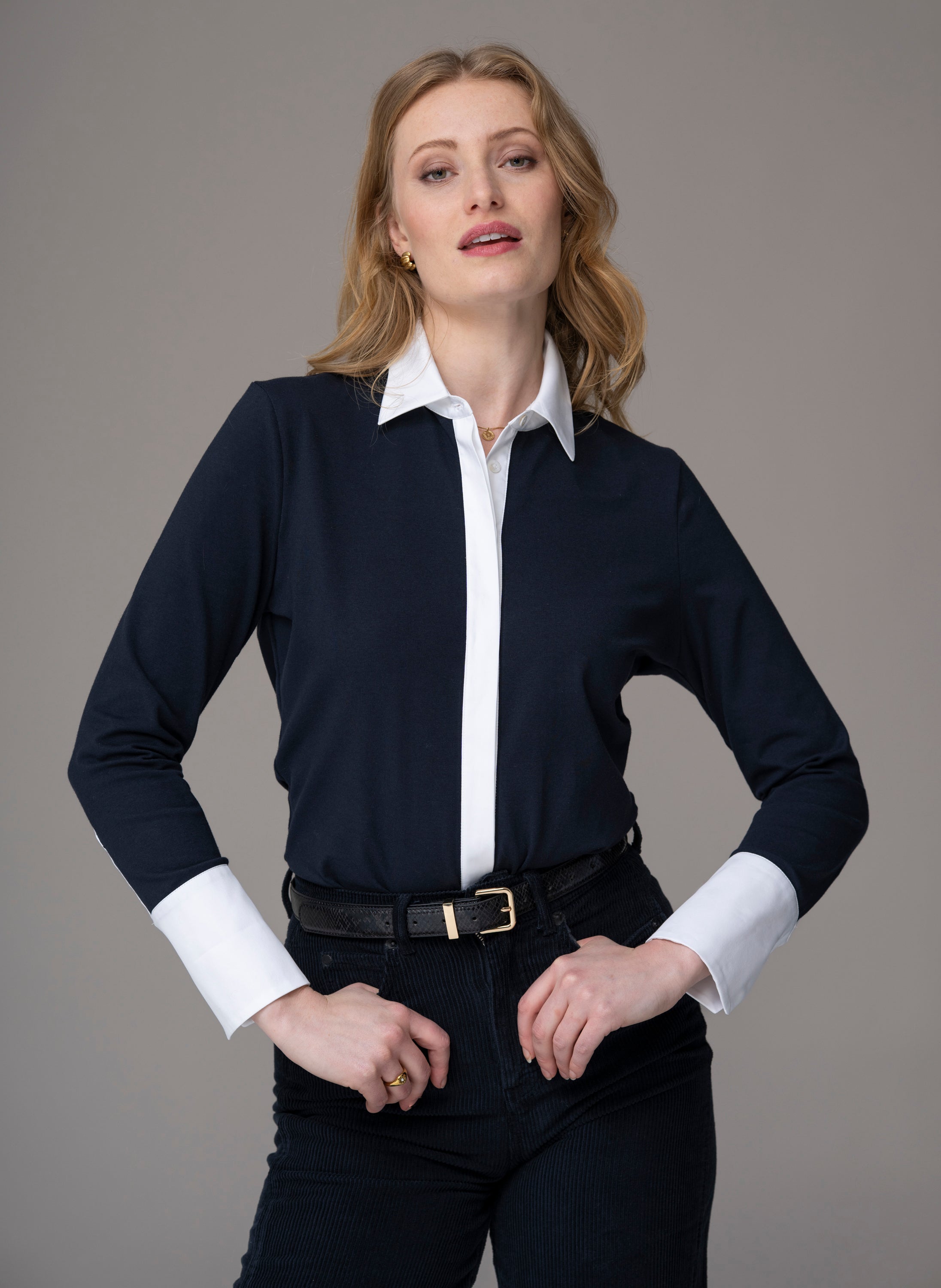 Woman wearing a navy jersey shirt with white cuffs and white collar