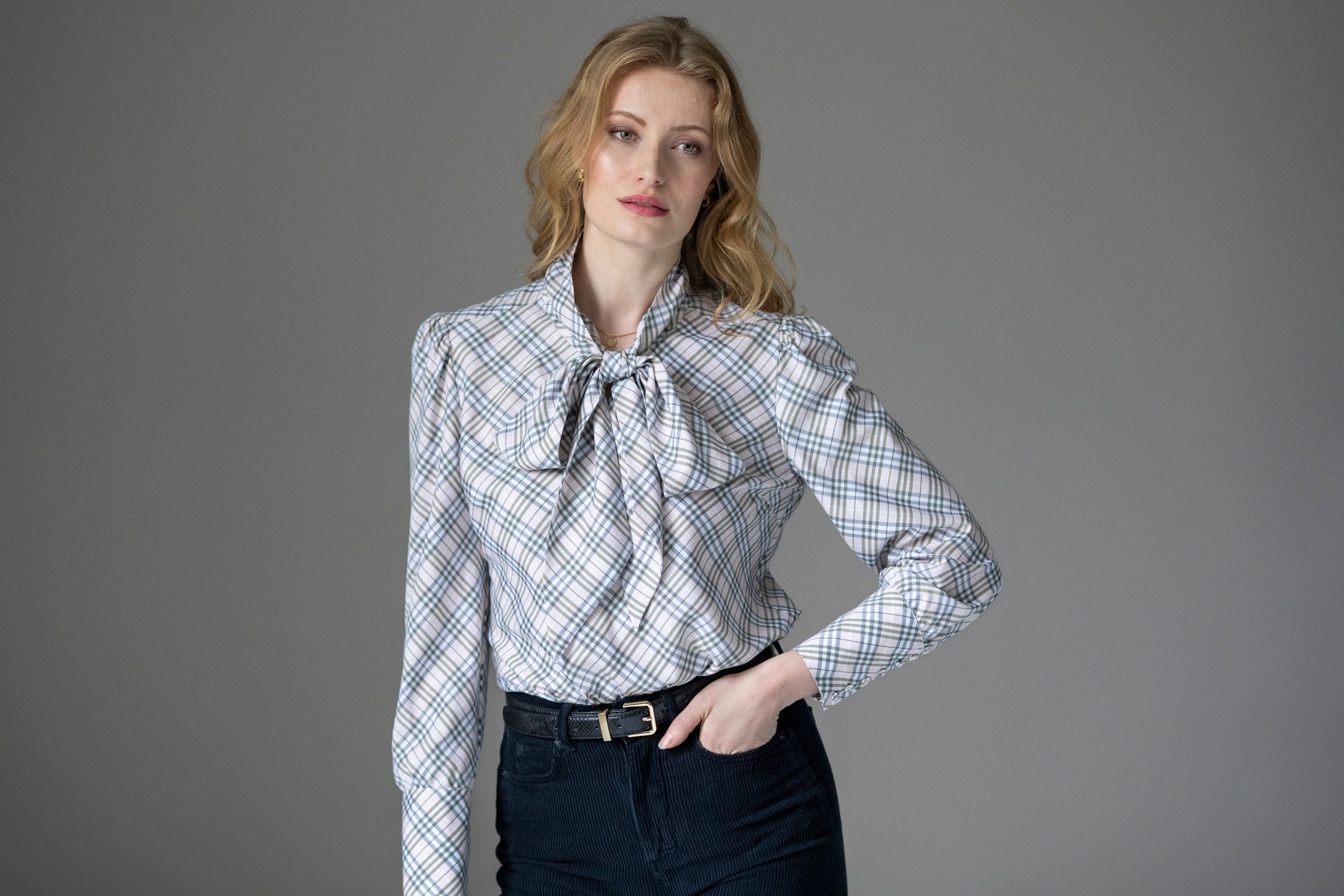 Woman wearing a plaid shirt with a pussy bow tie