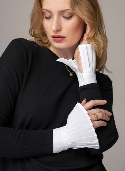 Woman wearing white pleated sleeves  or poignets plissé with black wool top