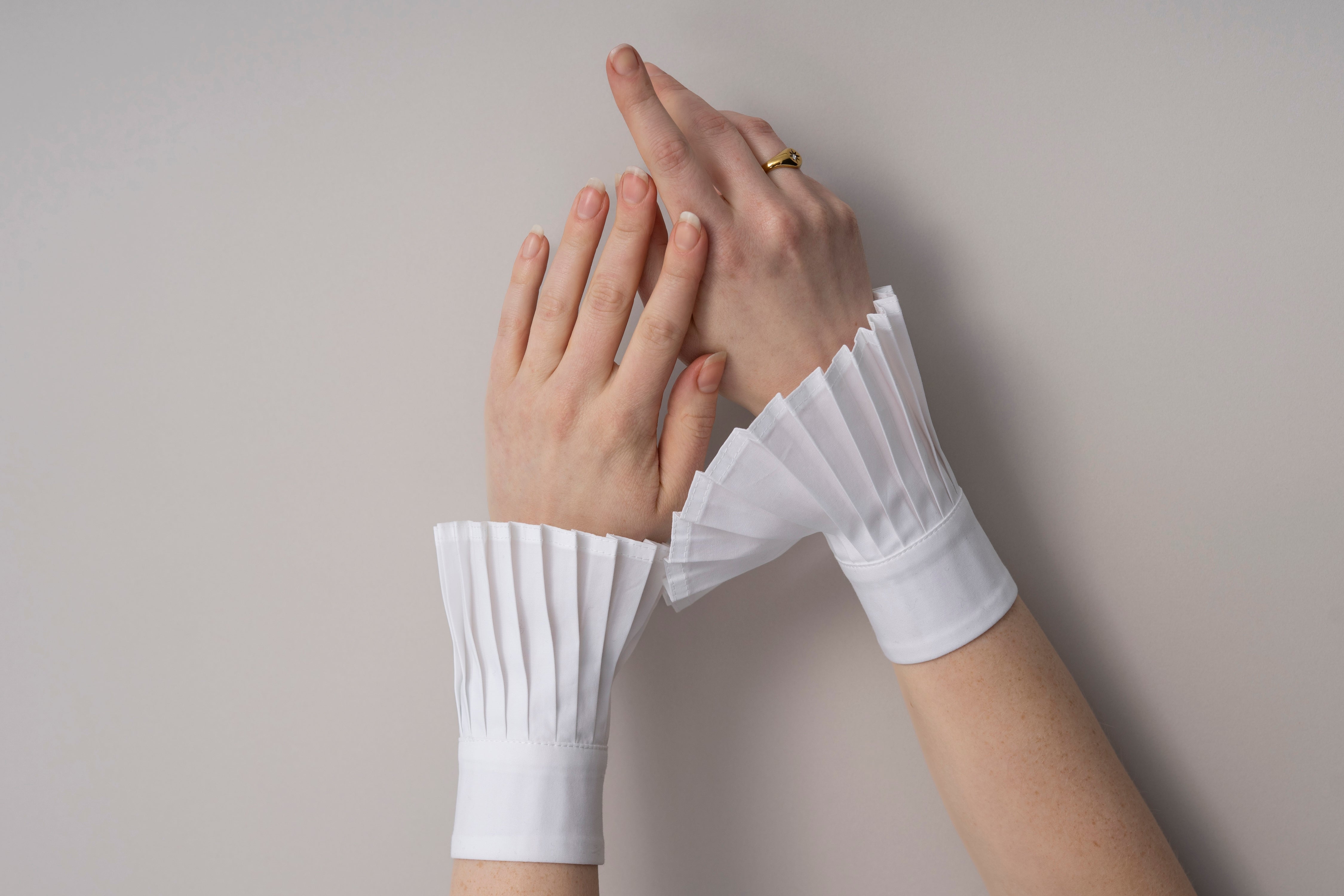 Female hands wearing white pleated sleeves  or poignets plissé 