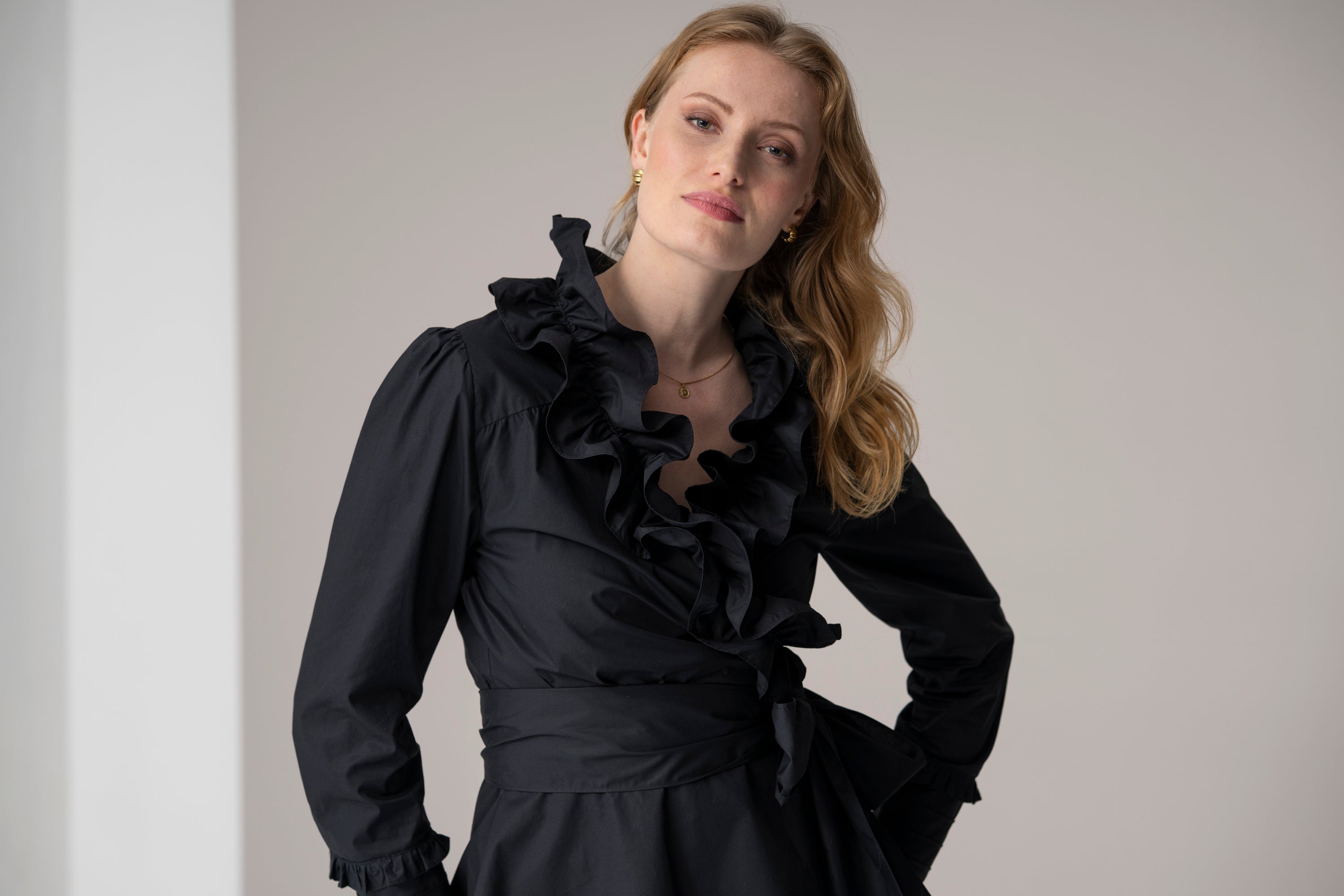 woman wearing black wrapover blouse with ruffles