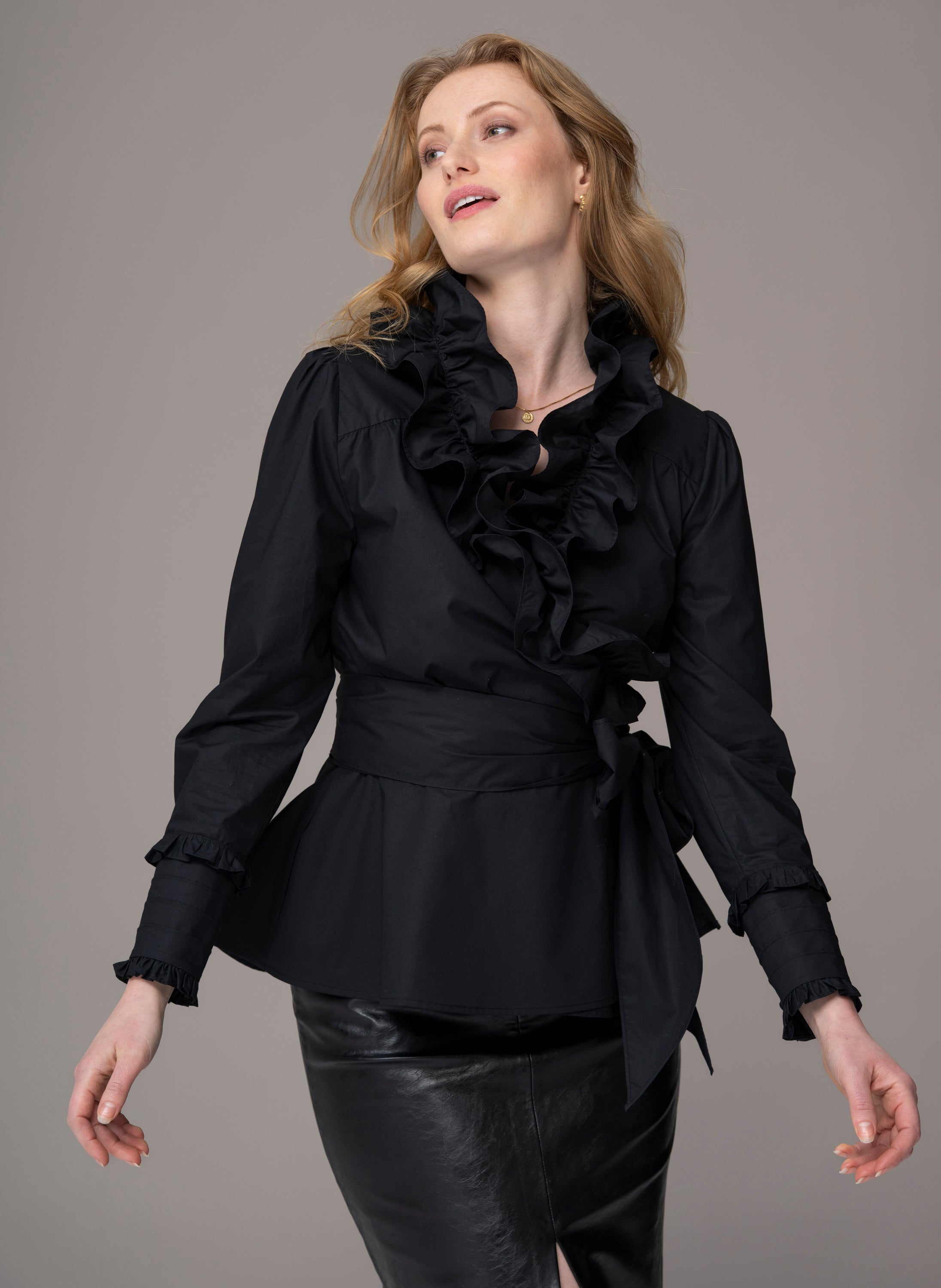 woman wearing black wrapover blouse with ruffles