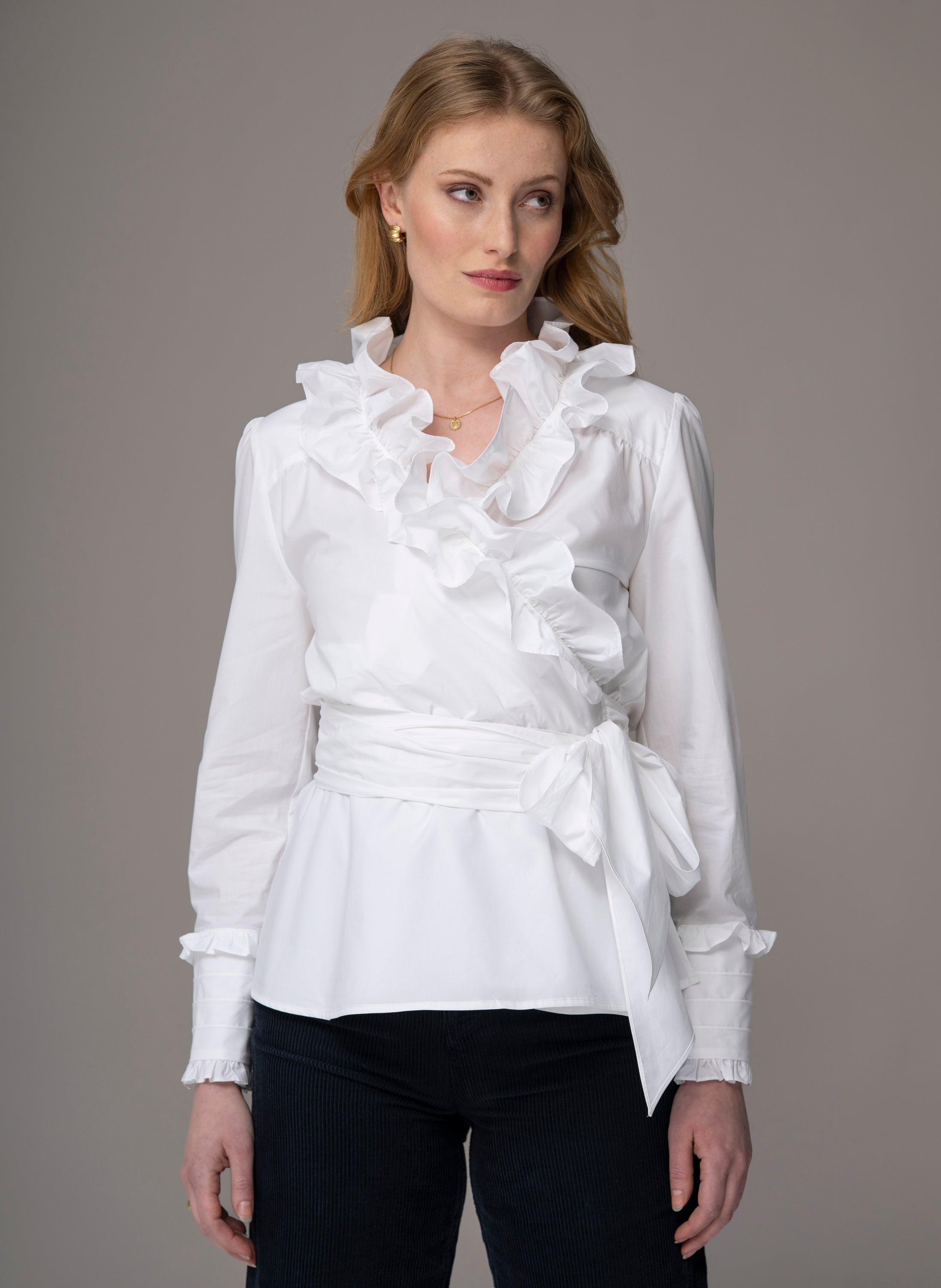 woman wearing white wrap-over blouse with ruffles