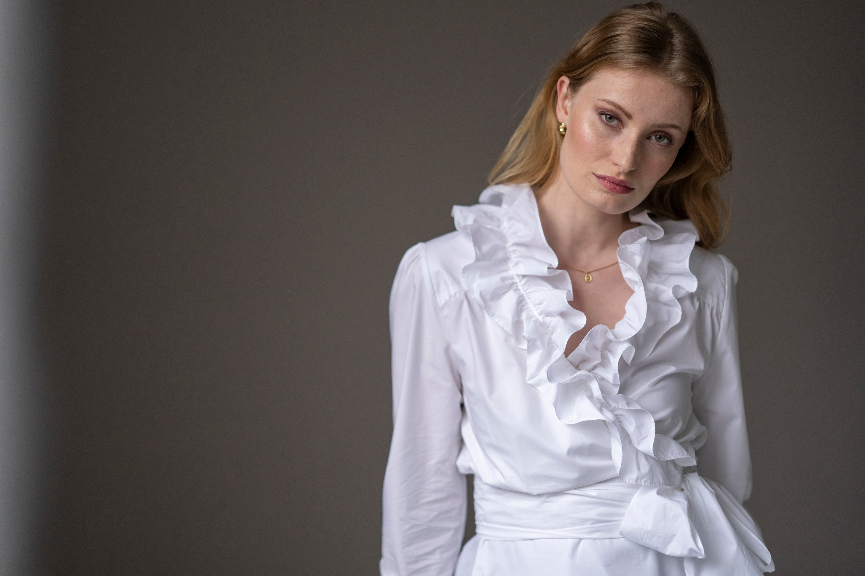 woman wearing white wrap-over blouse with ruffles